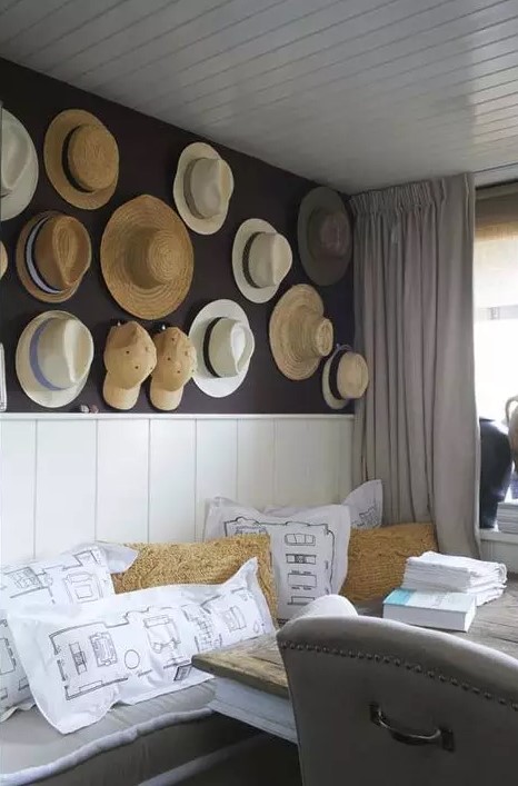 a farmhouse space with a whole wall of straw hats and baseball caps that adds eye-catchiness to the space and makes it warm and cool