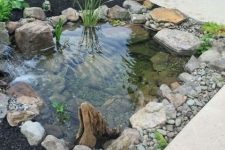 07 a small pond with water plants and rocks and pebbles looks lovely and very fresh and brings interest to the space
