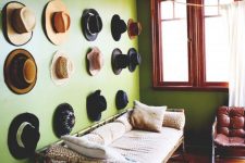 09 a hat gallery wall over a bamboo daybed, a burgundy leather chair and a printed rug are amazing for a bold space