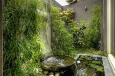 09 a stylish outdoor space with lush greenery, with a modern waterfall and a small pond with water plants and koi fish is amazing