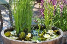 11 a barrel water garden with water lilies and greenery for a slight romantic and rustic touch to the space