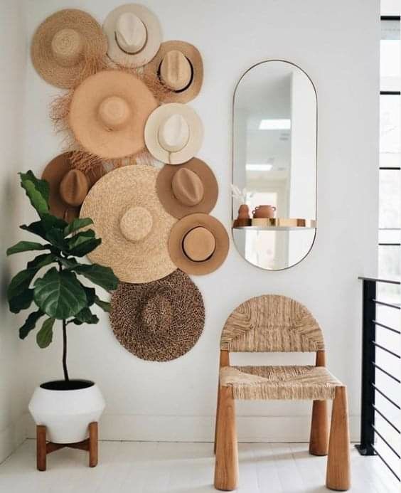 a hat gallery wall used as decor to add interest to a neutral boho space, it looks chic and lovely