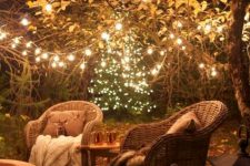 14 a stylish and cozy backyard with woven chairs, a table, some candle lanterns and string lights over the space
