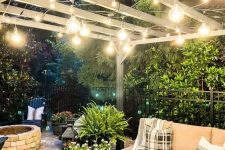 16 a stylish neutral outdoor space with a corner sofa, some stools, greenery, lanterns and string lights over the space