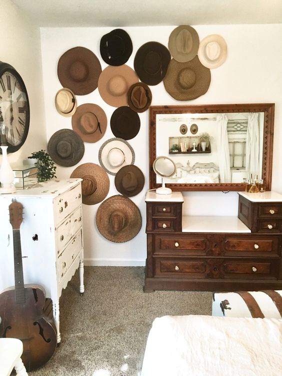 a shabby chic space with a shabby dresser, a white daybed, a dark stained dresser, a mirror in a dark stained frame and a hat gallery wall