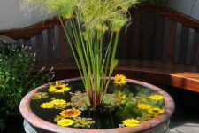 22 a mini pond of an oversized vintage porcelain urn with greenery, grasses and floating blooms is beautiful