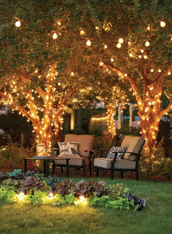 string lights covering the tree and hidden under the grasses give enough light to this cozy space