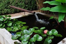 27 a small outdoor space with a box pond with water lilies and a waterfall plus greenery around is a lovely idea for a modern space