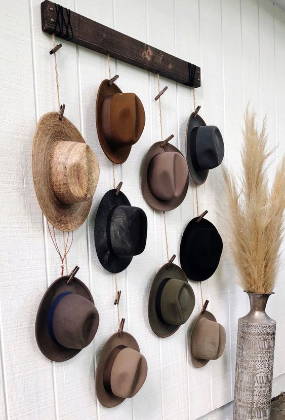 an industrial hat display of stained wood, rope and clothespins is a simple and lovely idea for a rustic or industrial space
