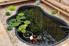 29 a wooden box with pebbles and growing plants and a small fish pond with water plants and greenery is a lovely idea for a rustic garden
