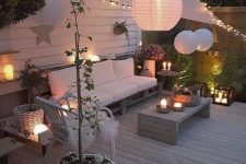 36 a welcoming deck with modern pallet and rattan furniture, candle lanterns, string lights and paper lamps over the space