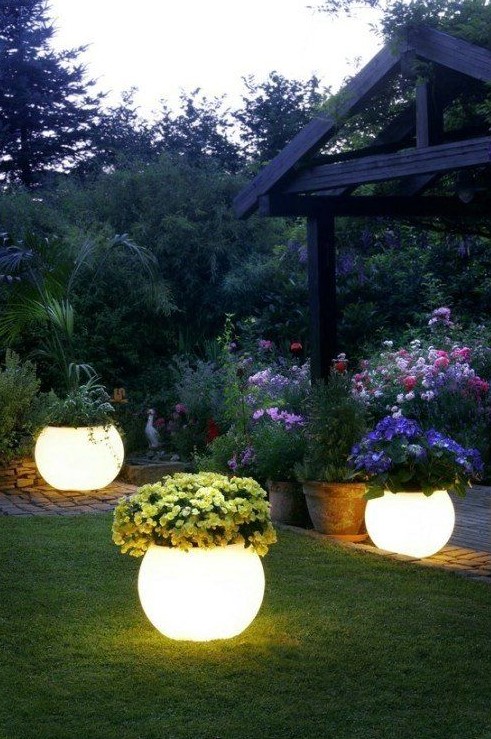lit up planters with blooms are a very creative way to light up your garden and bring a decorative value at the same time