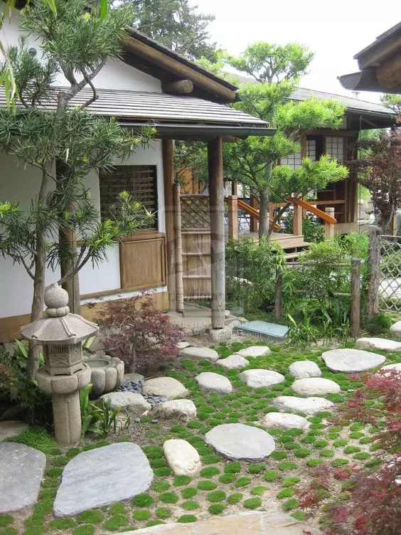 a Japanese front yard with greenery, rock steps, a lantern and a couple of trees is a gorgeous idea if you love Japanese design