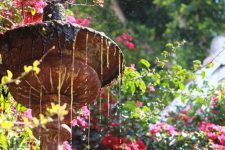 a beaitiful blooming garden with a traditional tiered fountain looks awesome and lovely and invites in
