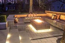 a beautiful sunken pation with built-in lights, a fire pit and lots of pillows invites to spend time here