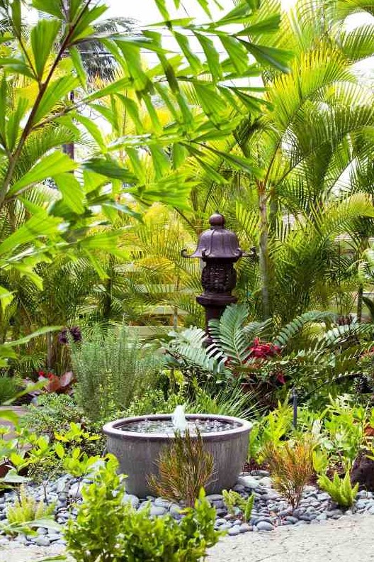 a bold Asian-inspired garden with a planter fountain surrounded with pebbles is always a good idea