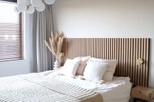 a lovely bedroom with a wood slat wall