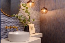 a catchy powder room with navy penny tiles, a textural wall, a floating stone vanity and a bowl sink, a cluster of pendant lamps