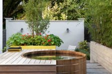 a cedar soaking tub is surrounded by ipe hardwood decking, with bamboo planted in a cast concrete planter is gorgeous