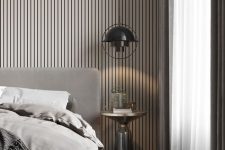 a contemporary geige bedroom with a wood slat headboard wiht lights, a grey upholstered bed with grey bedding, a black pendant lamp