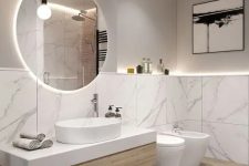 a contemporary greige bathroom clad with white marble tiles, a floating vanity, white appliances and neutral chromatic fixtures, pendant bulbs