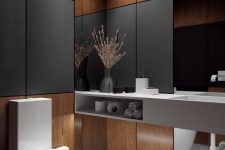 a contemporary powder room with plywood and black panels, a mirror, a concrete vanity and some built-in lights