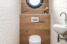 a contemporary powder room with wood-inspired tiles, geometric white ones, a window, a wall-mounted sink