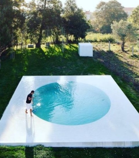a cool minimalist round pool with a white frame around looks very eye-catching and allows relaxing on this watery deck, too