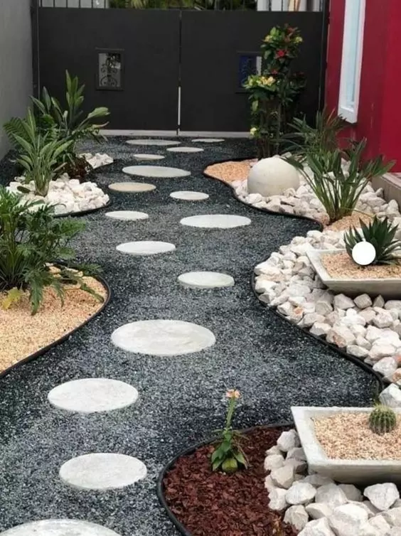 a front yard Japanese-inspried garden with gravel, round stone steps, some greenery and potted plants is all cool