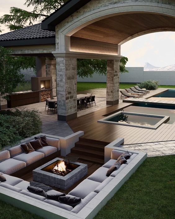 a gorgeous contemporary sunken patio with built-in benches and a fire pit in the center, with taupe pillows welcomes in