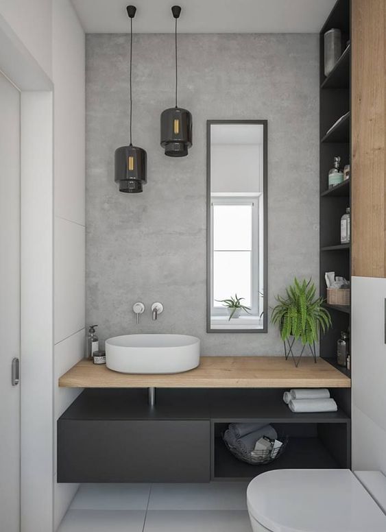 a lovely contemporary powder room with a grey accent wlal, a black floating vanity, a bowl sink, a duo of black pendant lamps
