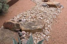 a low-water garden done with mulch, pebbles, large rocks and succulents is a great idea for a hot climate