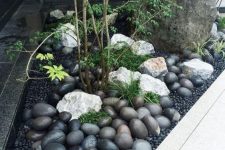 a mini front yard Japanese garden with large rocks and pebbles, some greenery and trees is a gorgeous idea for a contemporary home