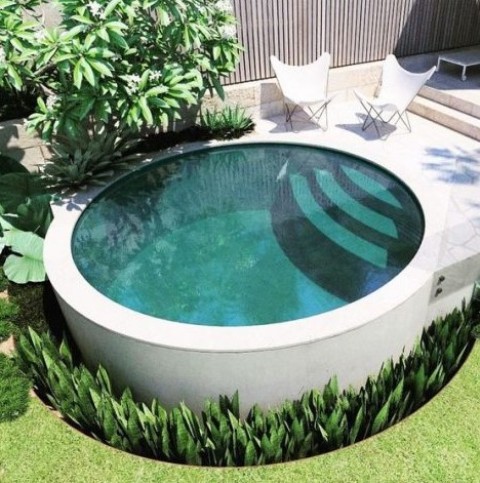 a minimalist round pool with steps surroundded with succulents and with a stone terrace and butterfly chairs