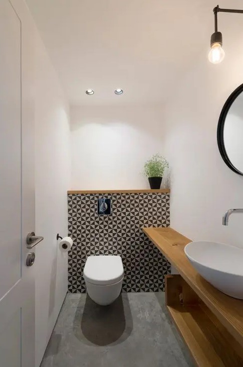 a modern powder room with an open timber vanity, a bowl sink and a mirror, an accent geo wall