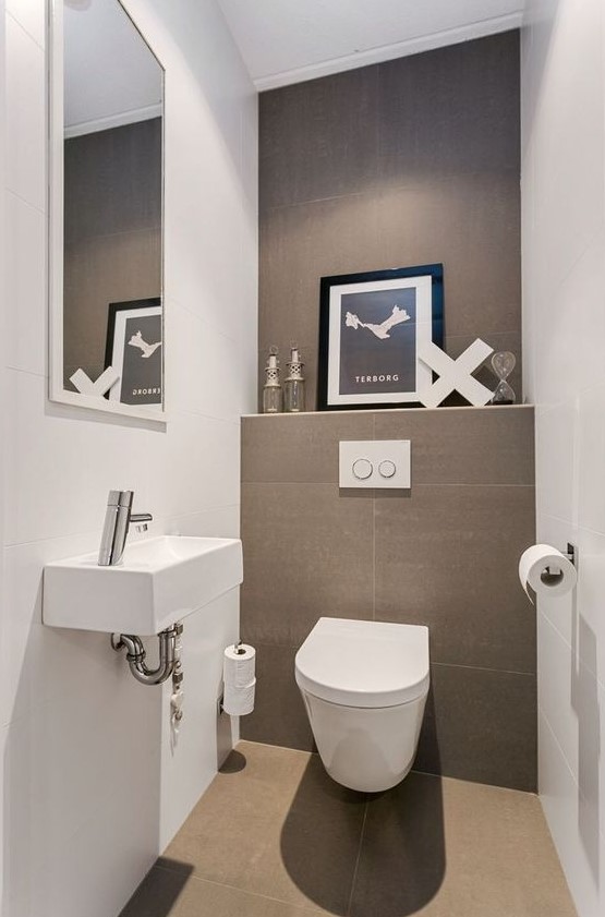 a neutral contemporary powder room done in taupe and white, an artwork, a wall-mounted sink and a large mirror