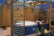 a pretty deck space with a hot tub, side tables, potted and growing plants and a bit of string lights and lanterns