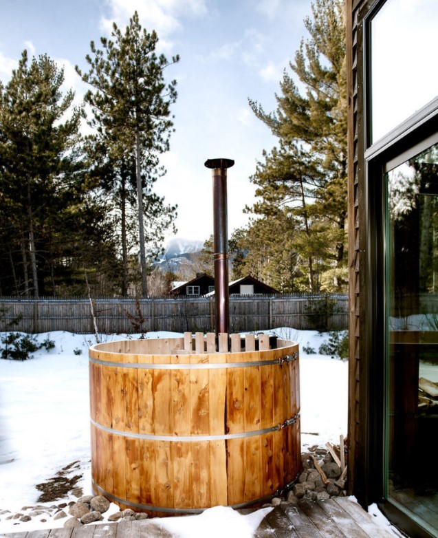a small cedar hot tub on a deck is more than enough to enjoy view of mountains and woods around