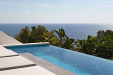 a small yet chic infinity pool with a wooden deck and minimalist loungers plus a fantastic sea view is amazing