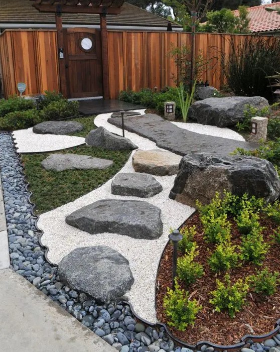 a stylish Japanese front yard with pebbles, rocks, greenery, a rock path and lanterns is a lovely modern decor idea