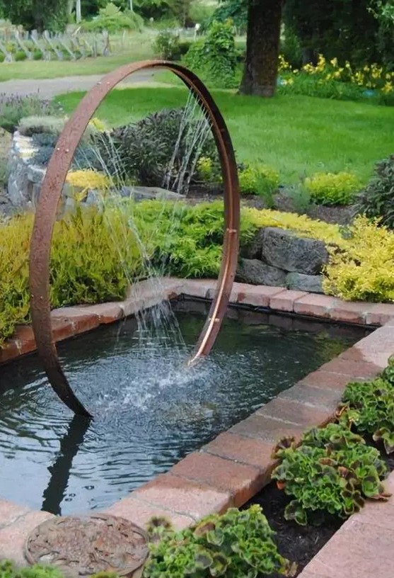 a super creative modern fountain composed of a metal wheel and placed into a pond will catch an eye in your garden