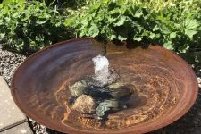 a super simple modern bowl fountain with rocks on the bottom is a great water feature for a modern garden, and your pets can refresh themselves in it