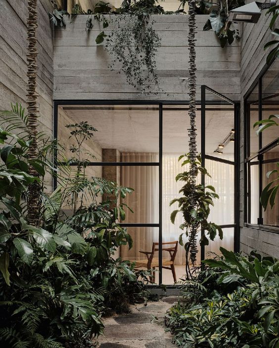 a townhouse courtyard that is garden clad with stone and with lots of greenery is a gorgeous space to be in