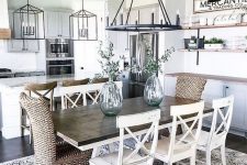 an airy modern farmhouse dining area with a wooden table, wicker and wooden chairs and open shelving