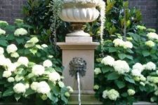 an elegant vintage fountain with a bowl with greenery on top and a large pool or pond for flowing in is a lovely idea for an elegant vintage-inspired garden