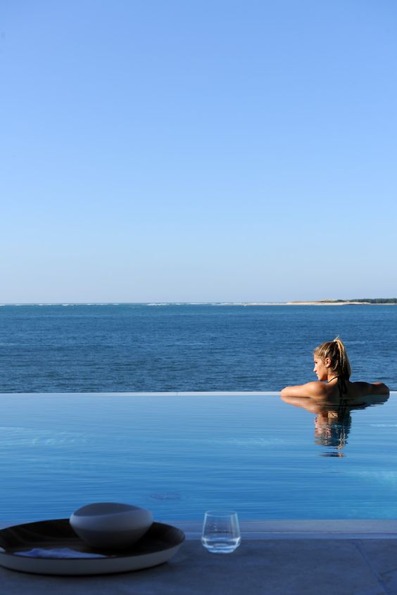 an infinity pool with a gorgeous sea view and a stone deck is all you need to have ultimate relaxation