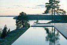 an infinity pool with a lake and woodland views and a stone deck is a perfect addition to your contemporary or minimalist house