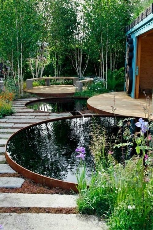 an outdoor space with two stock tank pools styled more as ponds for a natural feel in the space