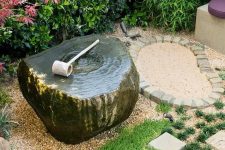 grass, pebbles, bricks and a stone fountain bowl with a wooden scoop for a casual and relaxed Japanese feel in the garden