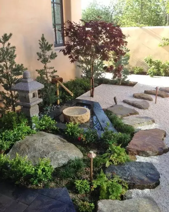 pebbles, rocks and rock tiles, a stone and bamboo fountain, greenery, a stone lantern and thin Japanese-style trees for a cozy feel